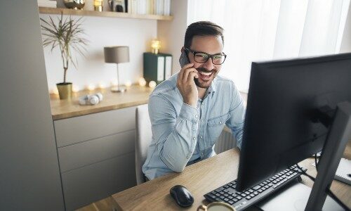 Man on conference call in home office setup illustrating importance of improving acoustics and sound quality in office design.